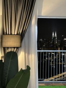 a room with a window with a view of the city at Lisa Homestay, KLCC View Homestay with Home Theatre in Kuala Lumpur
