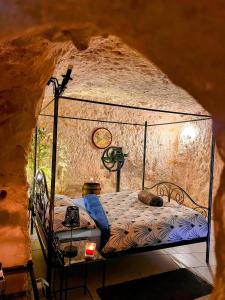 リュイーヌにあるTroglo Papillonの洞窟内のベッド1台が備わるベッドルーム1室を提供しています。