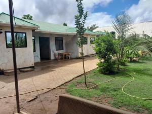 a house with a green roof and a garden at Kilibase Hotel in Moshi