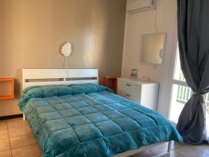 Mirabella ImbaccariにあるB&B RosAngeloのベッドルーム1室(青い掛け布団、窓付)