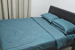 a bed with blue sheets and blue pillows at Kinta Riverfront Homestay (Riverside) in Ipoh