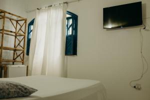 a bedroom with a bed and a television on a wall at Pousada Nel Blu in Itaparica