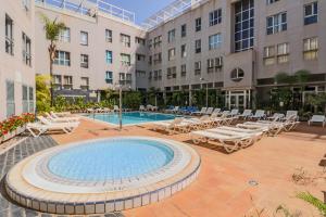 a swimming pool with lounge chairs and a hotel at Flatguest Sardina Home pool in Gáldar