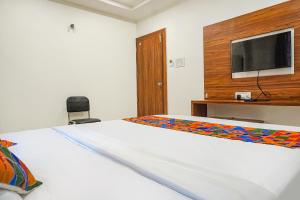 Uma cama ou camas num quarto em FabExpress Sathvik Executive
