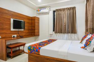 a bedroom with a bed and a television in it at FabExpress Sathvik Executive in Pune