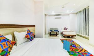 a bedroom with a king sized bed and a couch at FabHotel Meera Palace in Indore