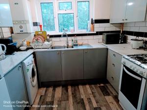 a kitchen with a sink and a washing machine at London's bed with breakfast in London