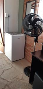 a white refrigerator and a fan in a room at Chácara Famille Brun in São João da Boa Vista