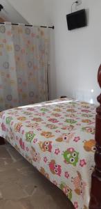 a bedroom with a bed with a floral bedspread at Chácara Famille Brun in São João da Boa Vista