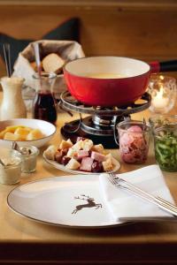 若特阿赫-埃根Spa & Resort Bachmair Weissach, LUXURY FAMILY RESORT的桌子上摆着一盘食物，炉子上放着一口锅