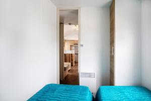 a bedroom with two beds and a mirror at Bungalow T3 I I -15 Min From Nazaré in Pataias