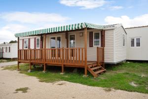 a tiny house with a porch and a deck at Bungalow T3 I I -15 Min From Nazaré in Pataias