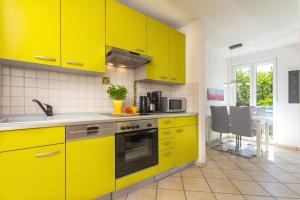 特拉森海德的住宿－Strandstrasse 21 Fewo 05，厨房配有黄色橱柜和桌椅