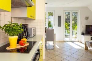 特拉森海德的住宿－Strandstrasse 21 Fewo 05，厨房配有黄色和白色的橱柜和桌子