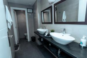 a bathroom with two sinks and a mirror and a toilet at Barcelona & You Hostel Sagrada Familia in Barcelona +29 photos