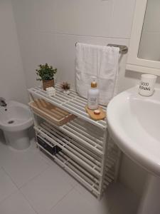 uma casa de banho branca com um lavatório e um WC em Casa Montecelo em Paderne