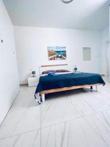 a white bedroom with a bed with a blue blanket at Sliema Luxury Apartments - Wish Malta in Sliema