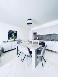 uma grande cozinha branca com uma mesa e cadeiras em Sliema Luxury Apartments - Wish Malta em Sliema