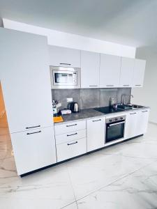 uma cozinha com armários brancos, um fogão e micro-ondas em Sliema Luxury Apartments - Wish Malta em Sliema