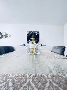 uma mesa com um frasco de perfume e taças de vinho em Sliema Luxury Apartments - Wish Malta em Sliema