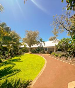 a walkway leading to a house with a green yard at Broadwater Resort WA Tourism Awards 2022 Gold Winner in Busselton