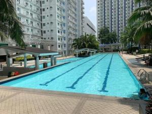 une grande piscine dans une ville avec de grands bâtiments dans l'établissement SMDC Grass Residences - Unit # 2816, à Manille