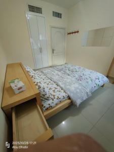 Dormitorio pequeño con cama y mesa en Bedroom 2, Couples should be married, en Abu Dabi