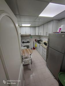 a small kitchen with a table and a refrigerator at Bedroom 2, Couples should be married in Abu Dhabi