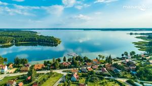 z powietrza widok na małe miasteczko nad jeziorem w obiekcie Mazurska Apartamenty w Rydzewie