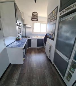 cocina con electrodomésticos blancos y suelo de madera en Appart hyper centre La Baule - Balcon vue dégagée, en La Baule