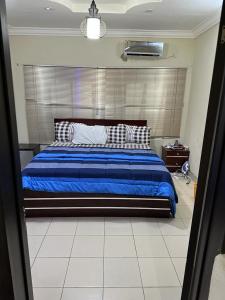 Schlafzimmer mit einem Bett mit blauer Bettwäsche und Kissen in der Unterkunft Mainstream Shortlet Apartments in Gbogije