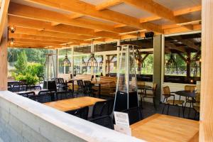 ein Restaurant mit Holztischen und -stühlen auf einer Terrasse in der Unterkunft RCN Vakantiepark de Noordster in Dwingeloo