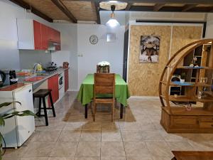 a kitchen with a table with a green table cloth on it at Maison meublée F2 avec vue et piscine in Ravine des Cabris