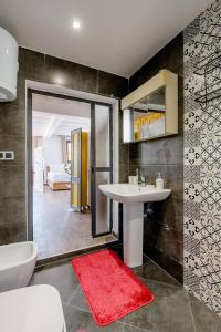 a bathroom with a white sink and a red rug at Studio Rooftop in Tangier