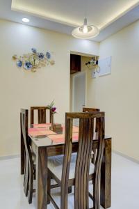 a dining room with a wooden table and chairs at Luxe 2BHK by Coral BnB with Pool access in Dabolim