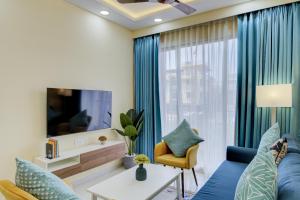 Televiisor ja/või meelelahutuskeskus majutusasutuses Luxe 2BHK 10min from GOI airport with Pool access