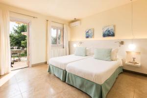 a bedroom with two beds and a large window at Hotel Sa Franquesa Nova in Vilafranca de Bonany