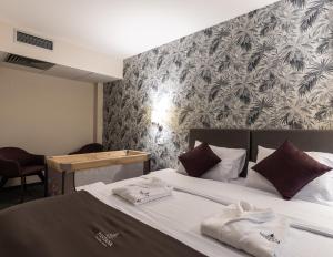 Una habitación de hotel con una cama con toallas. en Hotel Fontana Vrnjačka Banja, en Vrnjačka Banja