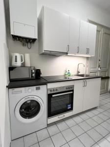 a kitchen with a washing machine and a microwave at Charming Apartment close to Vienna Central Station in Vienna
