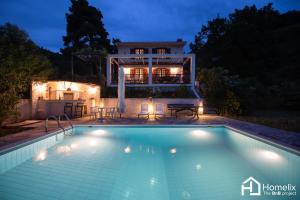 una piscina frente a una casa por la noche en Villa VERA - private villa for 8 guests with pool, en Kími
