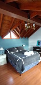 een groot bed in een kamer met houten plafonds bij Departamento Ushuaia in Ushuaia