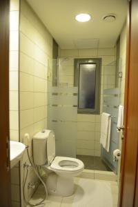 a white bathroom with a toilet and a sink at AlSharq Residence in Kuwait