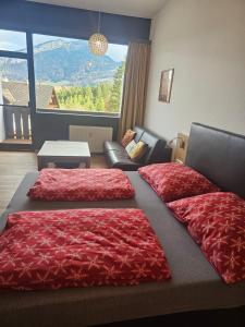 a bedroom with two beds and a couch and a window at Dachstein Blick in Bad Goisern