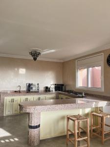 a kitchen with a counter and two stools in it at Ocean View Home in Mirleft