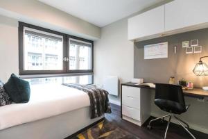 a bedroom with a bed and a desk and a chair at Premium Studios and 2 Bed Apartments at Chapter Old Street in London in London