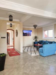 a living room with a blue couch and a table at Ocean View Home in Mirleft