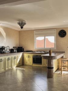 a large kitchen with yellow cabinets and a table at Ocean View Home in Mirleft