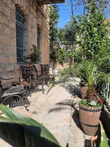 a courtyard with benches and plants in a building at הפינה היפה ליד החומות in Jerusalem