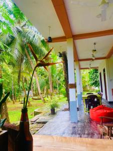 a room with a patio with a table and palm trees at Bunky Monkey in Hikkaduwa