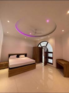 - une chambre avec un lit au plafond violet dans l'établissement Mauji's Villa Hotel & Guest House, à Prayagraj